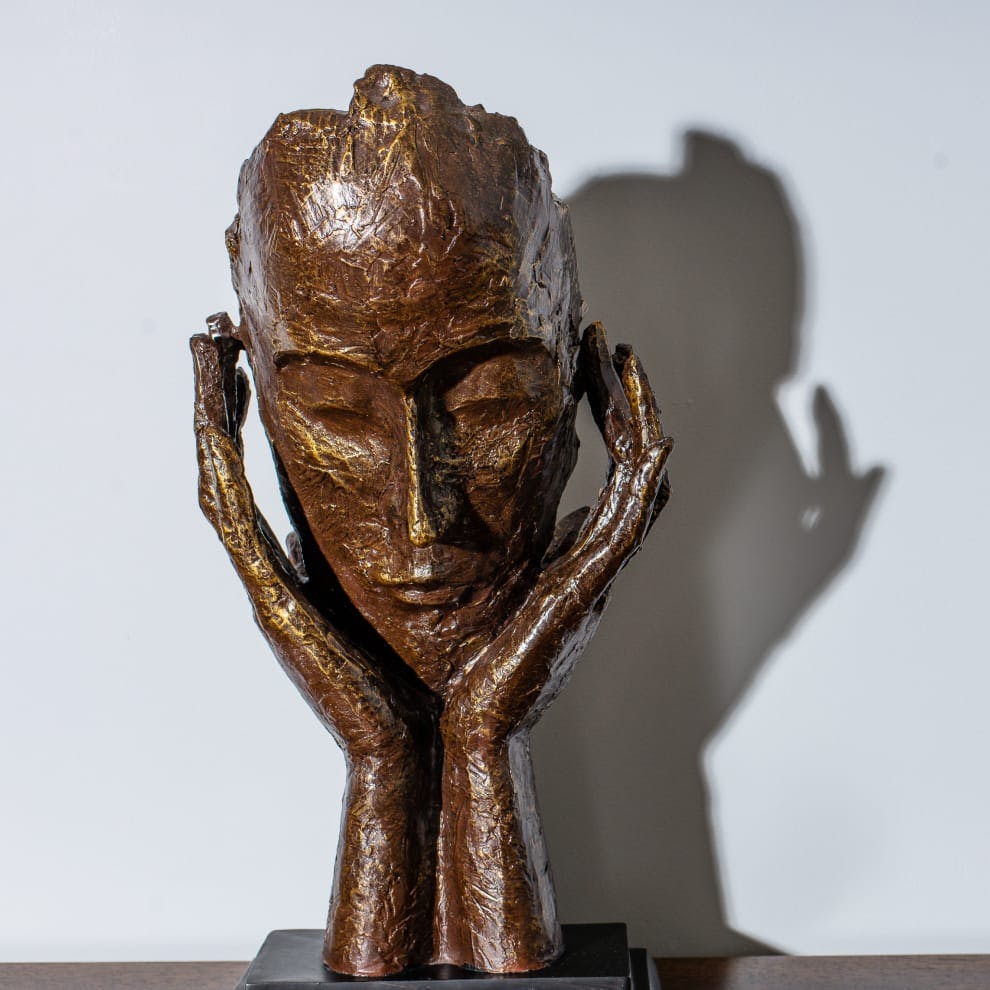 person cupping their face statue