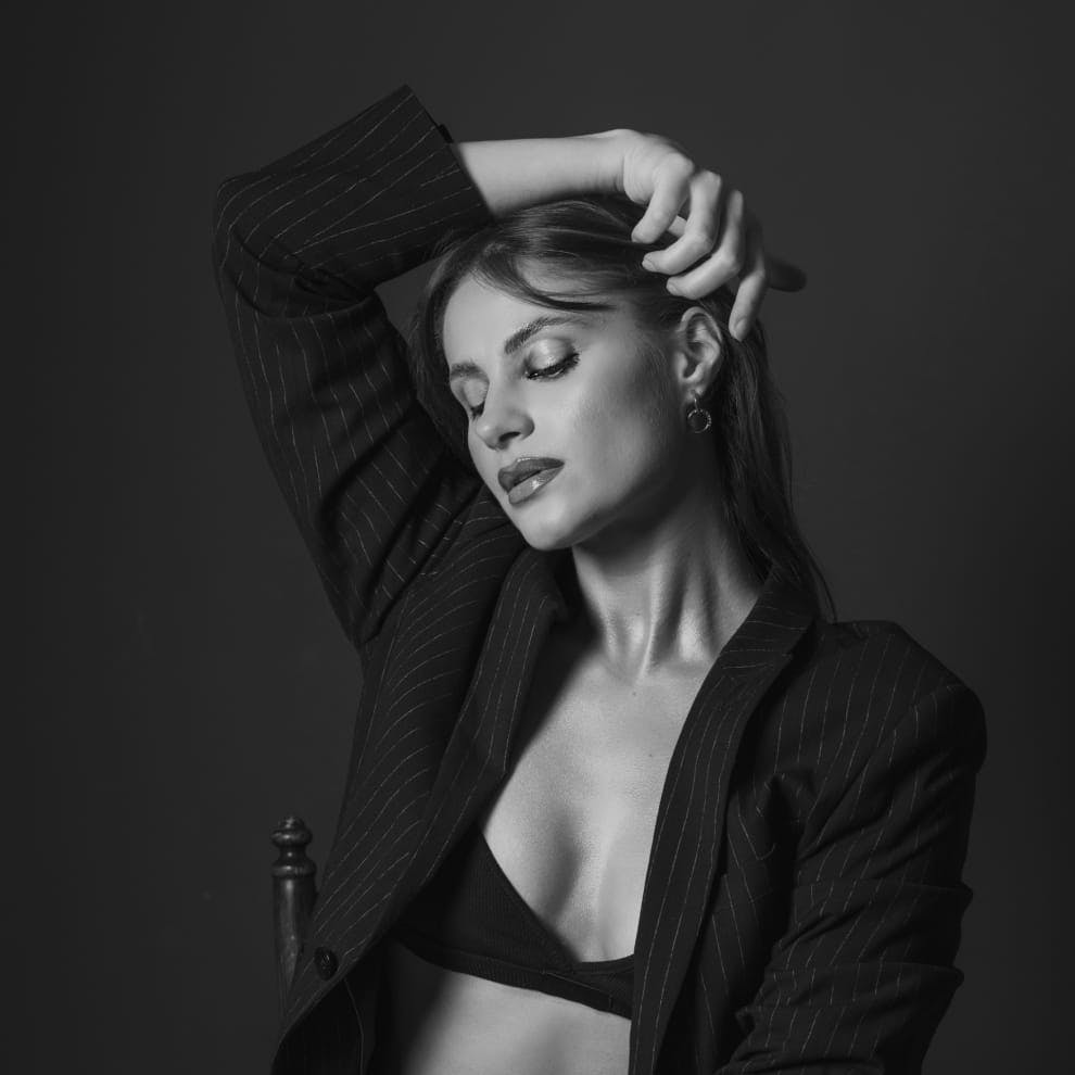 woman wearing a black suit jacket over a bralette