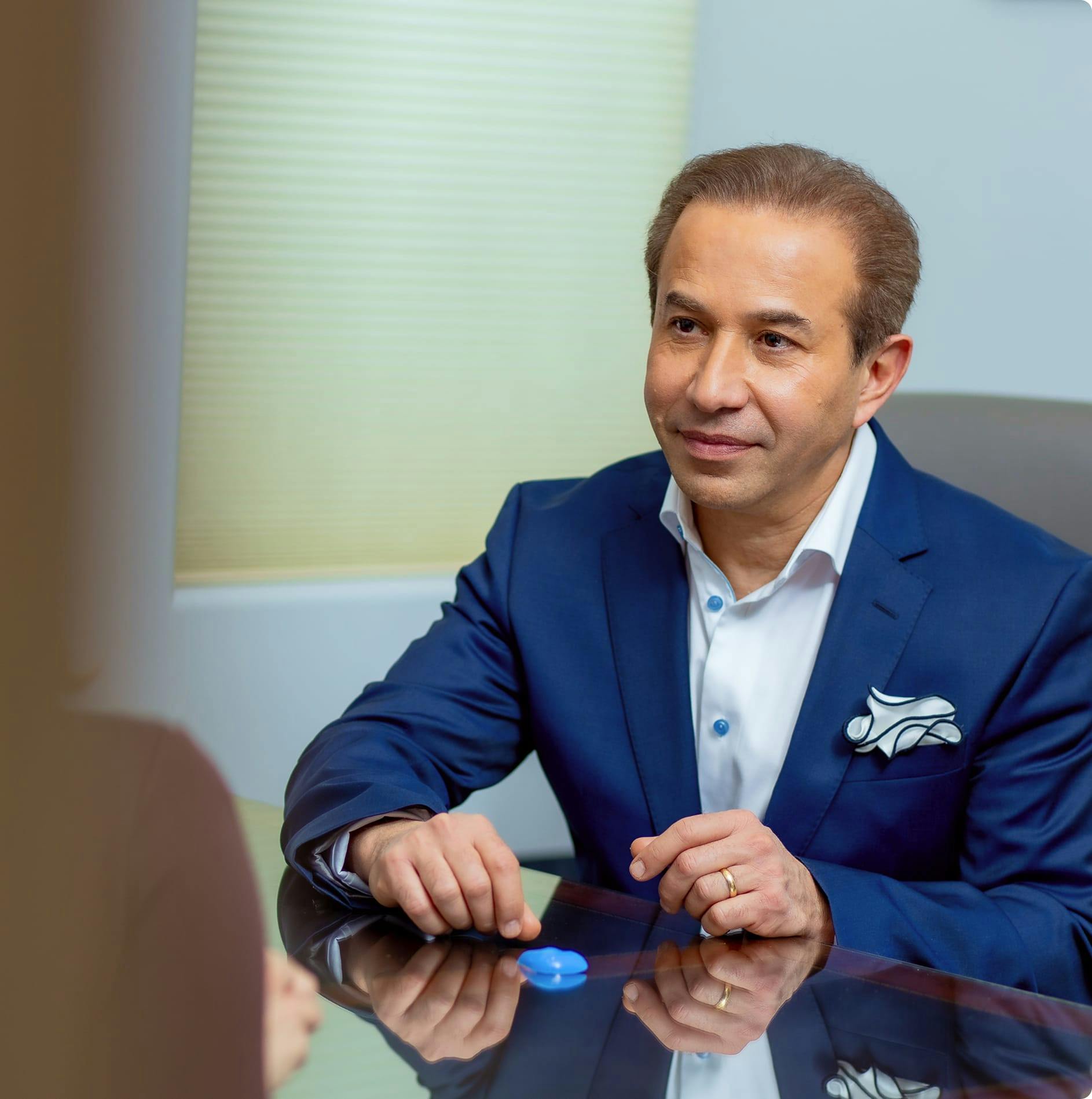 Dr. Bolourian in a suit at a table