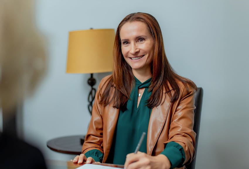 Woman smiling signing documents