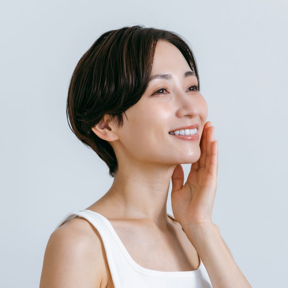 woman with short hair touching the side of her face