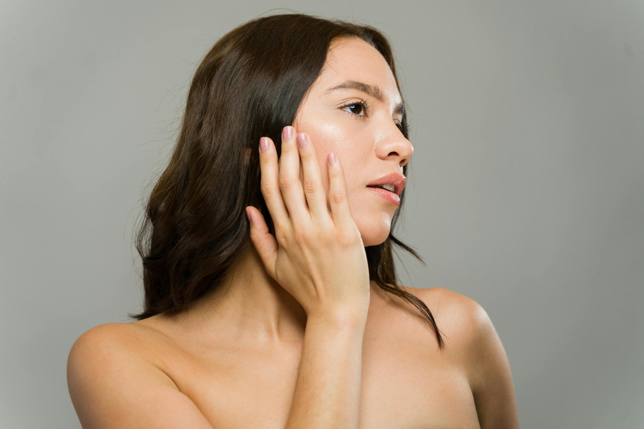 woman gently touching her face