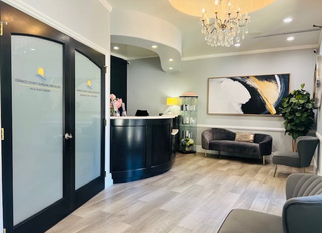Reception area with front desk, chandelier lighting, and seating