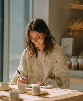 Woman participating in a food and beverage taste testing session, taking notes during a consumer product evaluation.