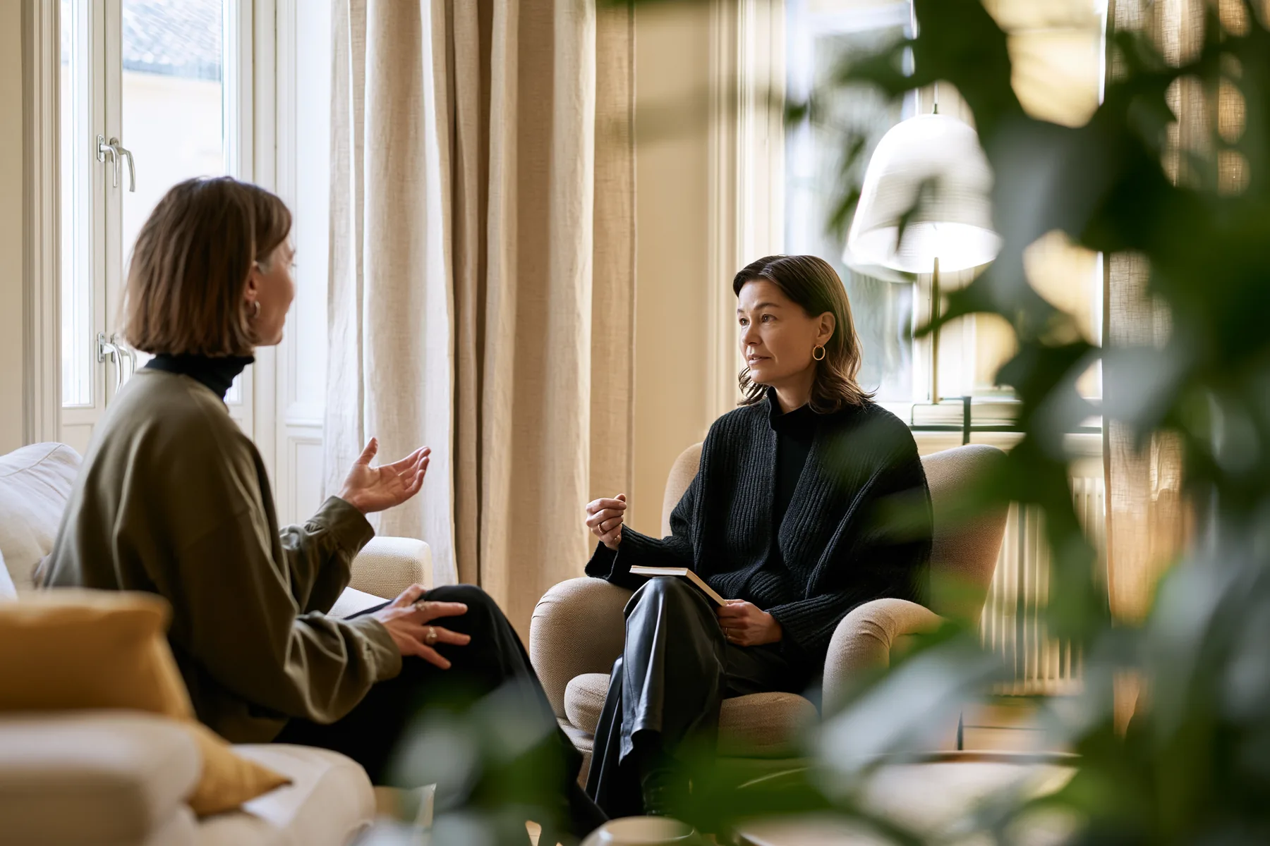 A moderator listening to a participant during a one-to-one in-depth interview in her living room
