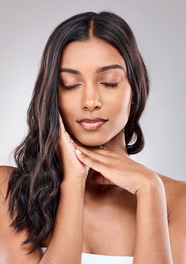 Woman with hands under chin used as category card for Face and Neck services