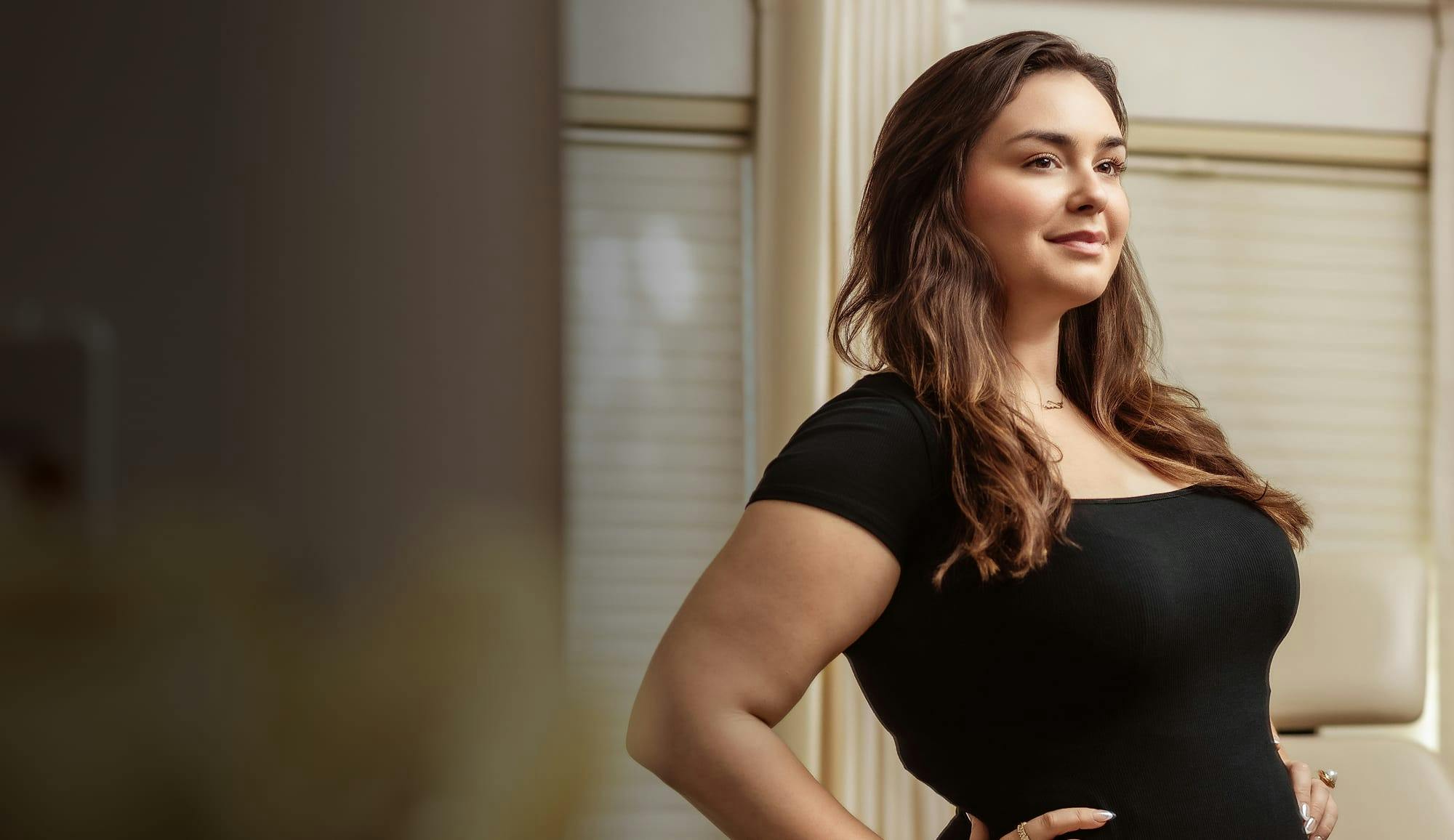 Confident woman with arms on hips, representing body treatments