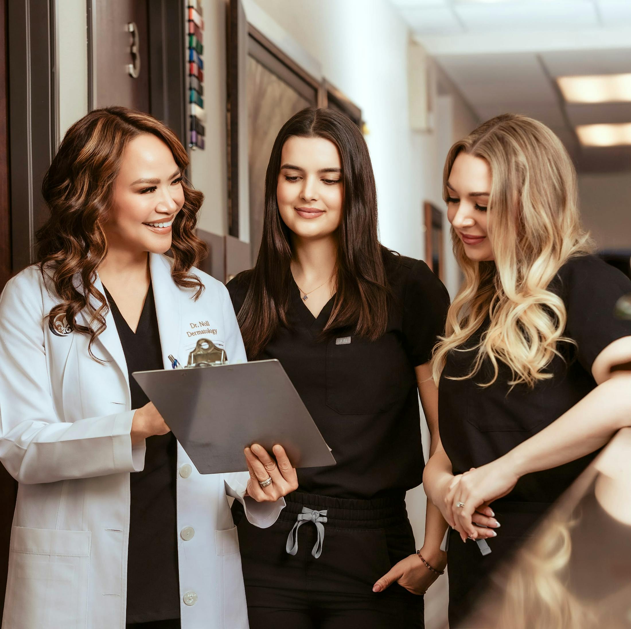 Dr. Noll standing with two female colleagues holding a tablet