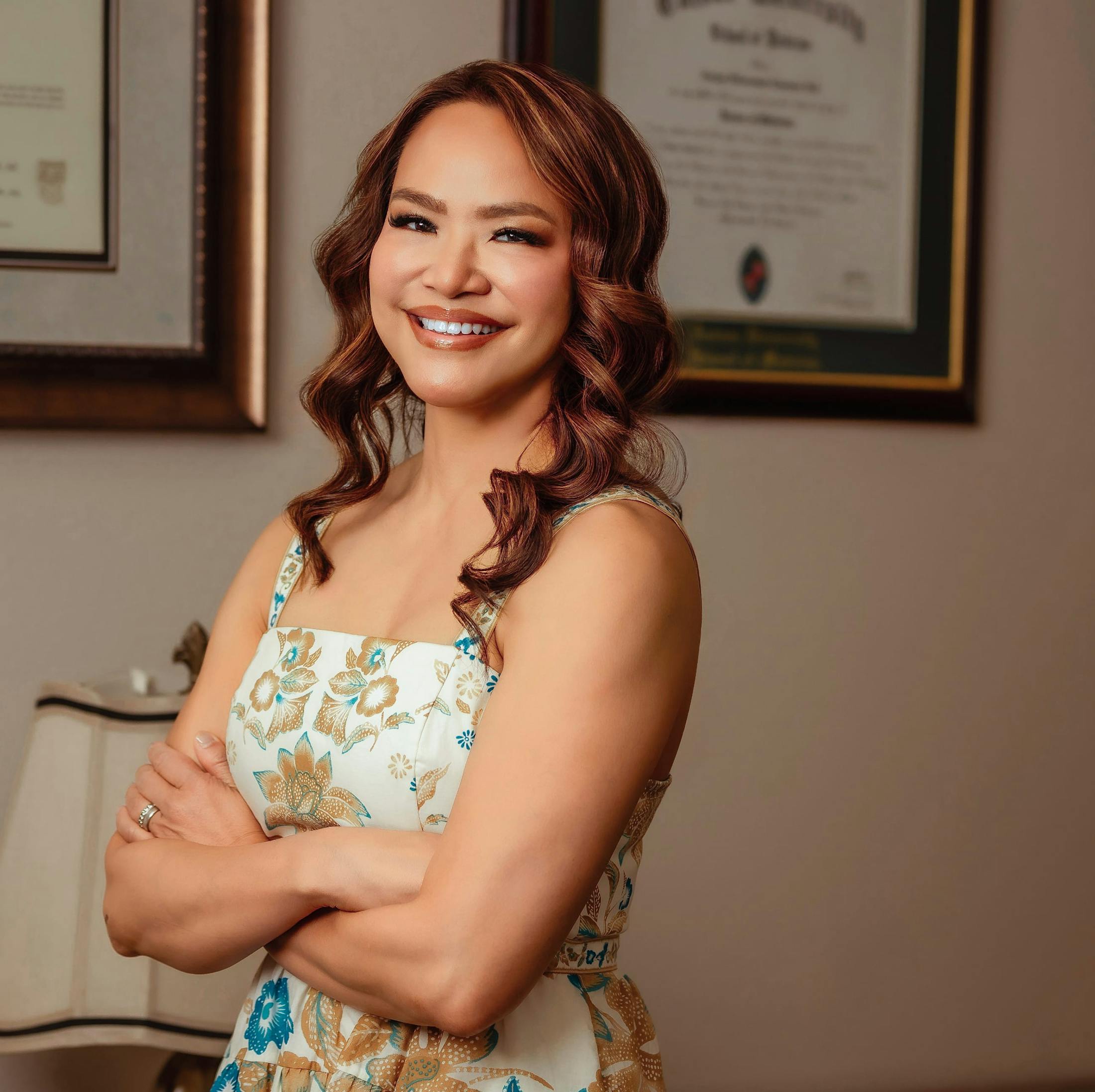Dr. Noll seated with arms crossed in a floral dress