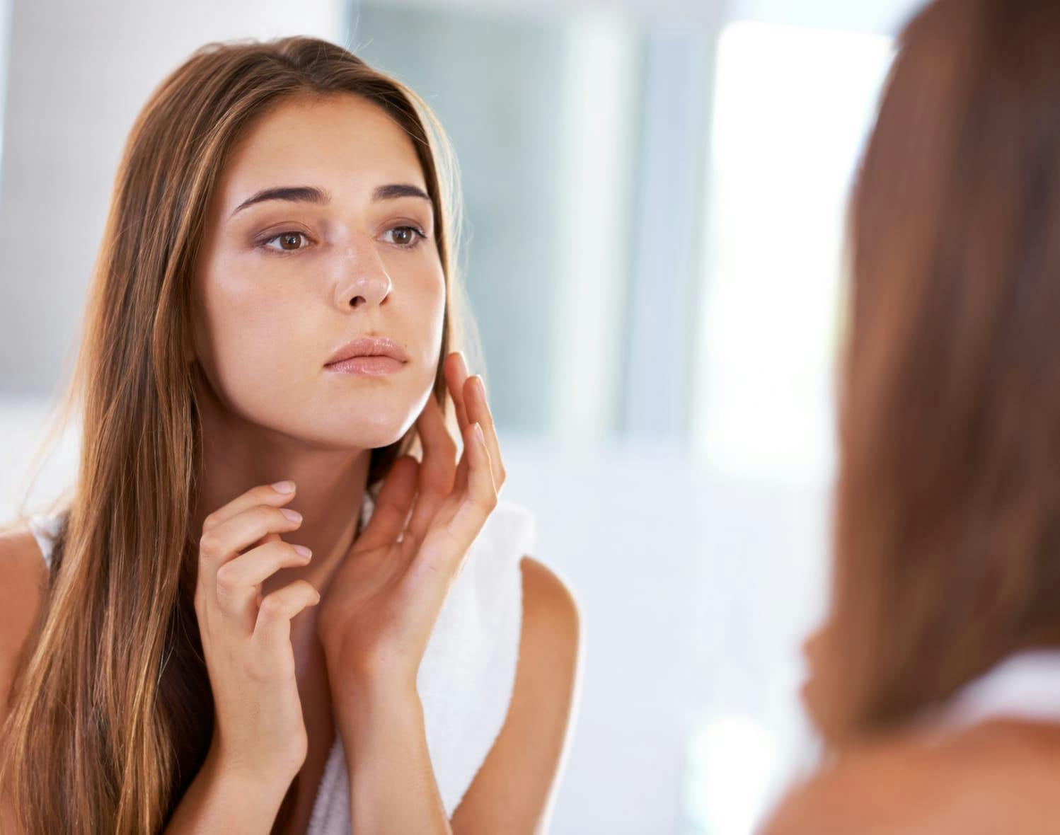 woman looking at herself in the mirror