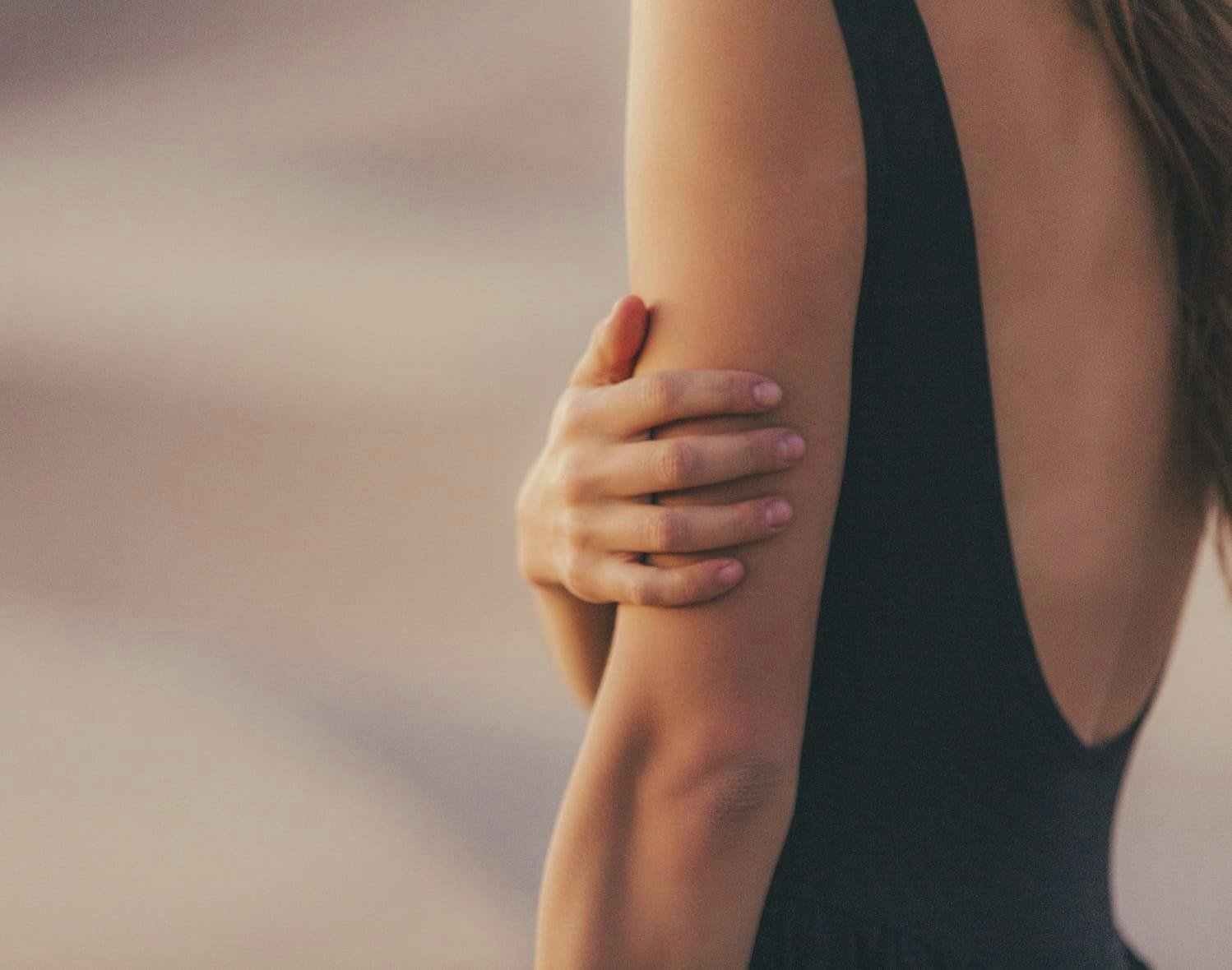 woman touching her arm