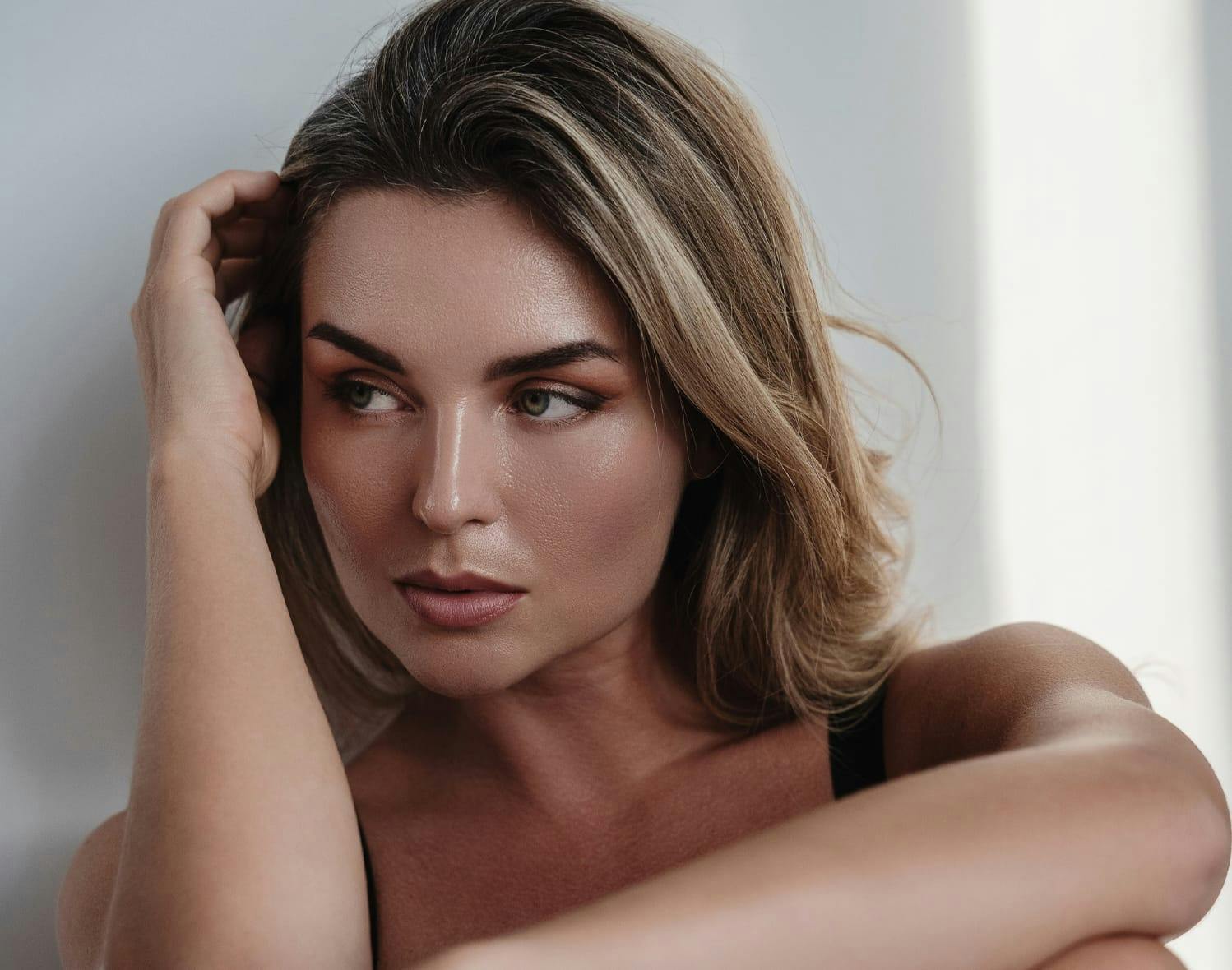 woman looking to the left with her arm near her face