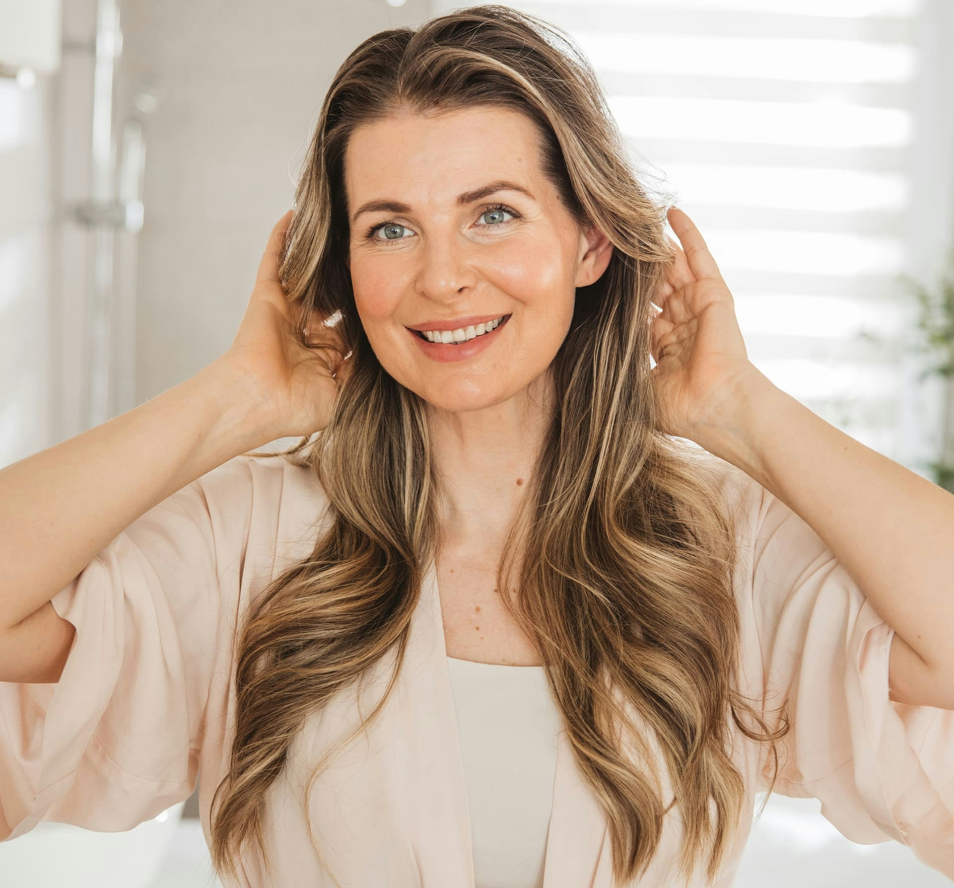 woman smiling and touching her hair