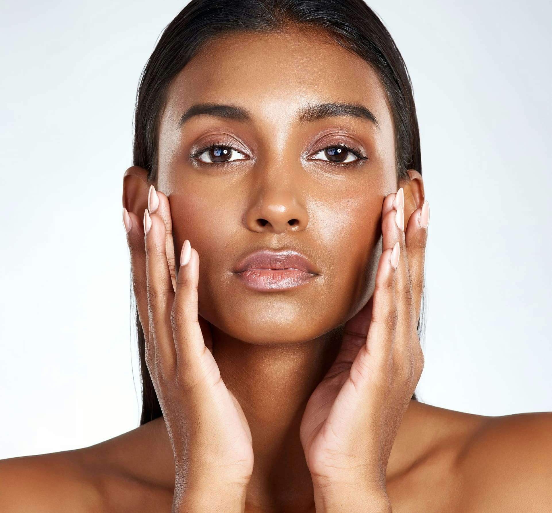 woman looking forward and touching her face