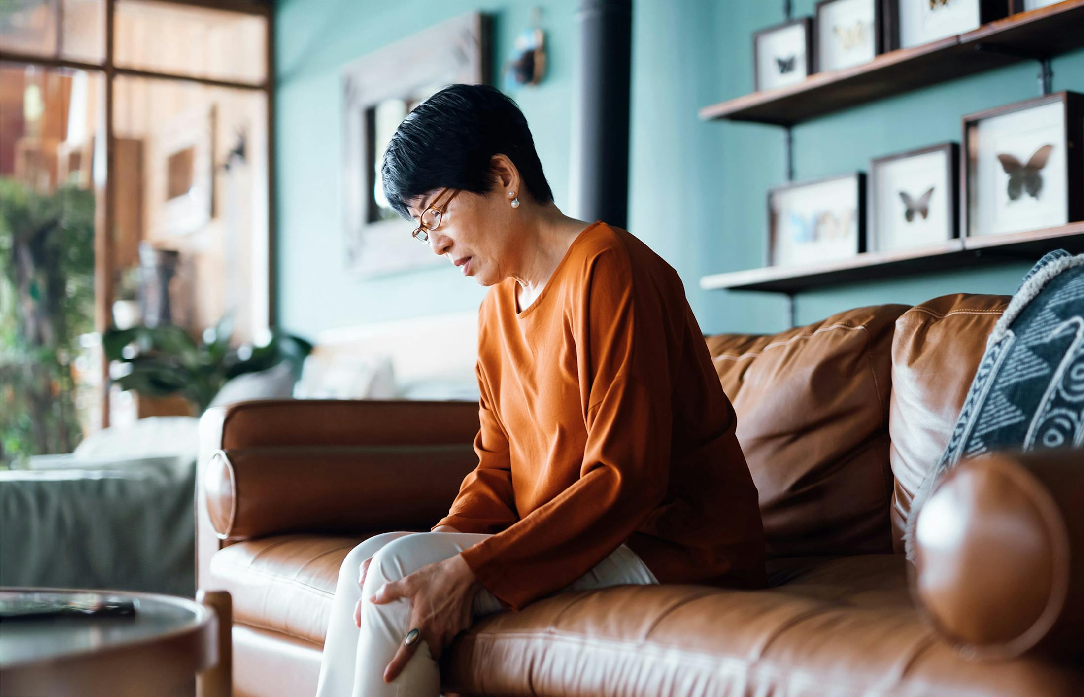 A woman sitting on couch with leg pain