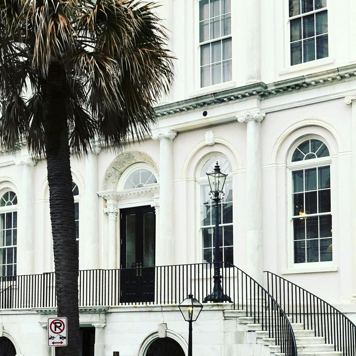 view of an elegant building with curved stairs leading to the door