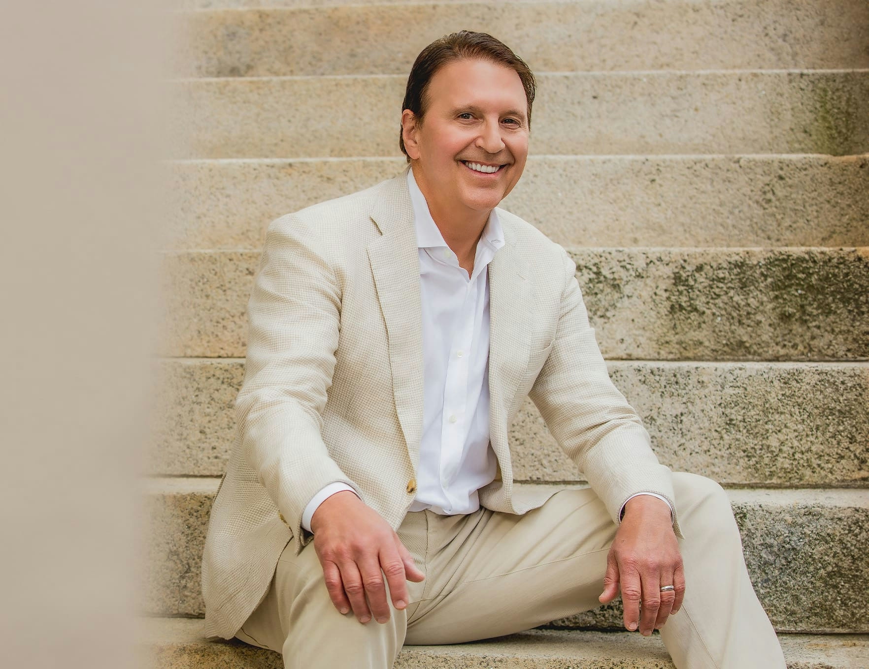Dr. John Rink smiling and sitting on stairs