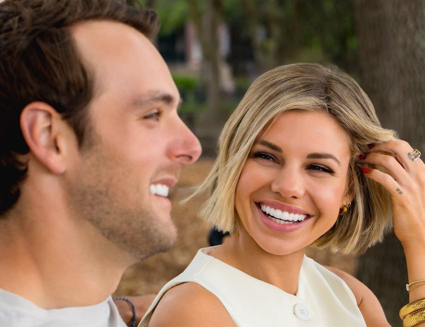 woman smiling at man while she moves her hair out of her face
