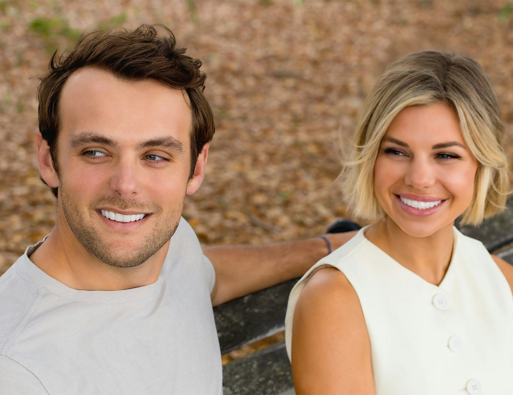 man and woman sitting on bench and smiling together