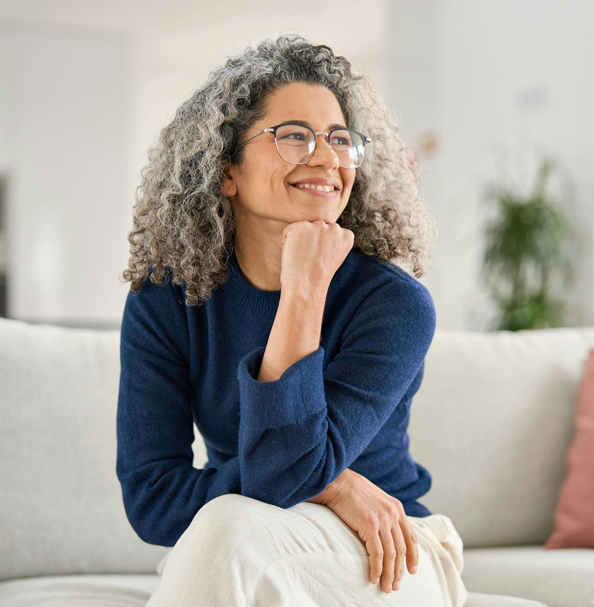 older woman sitting on the couch with her chin on her hand