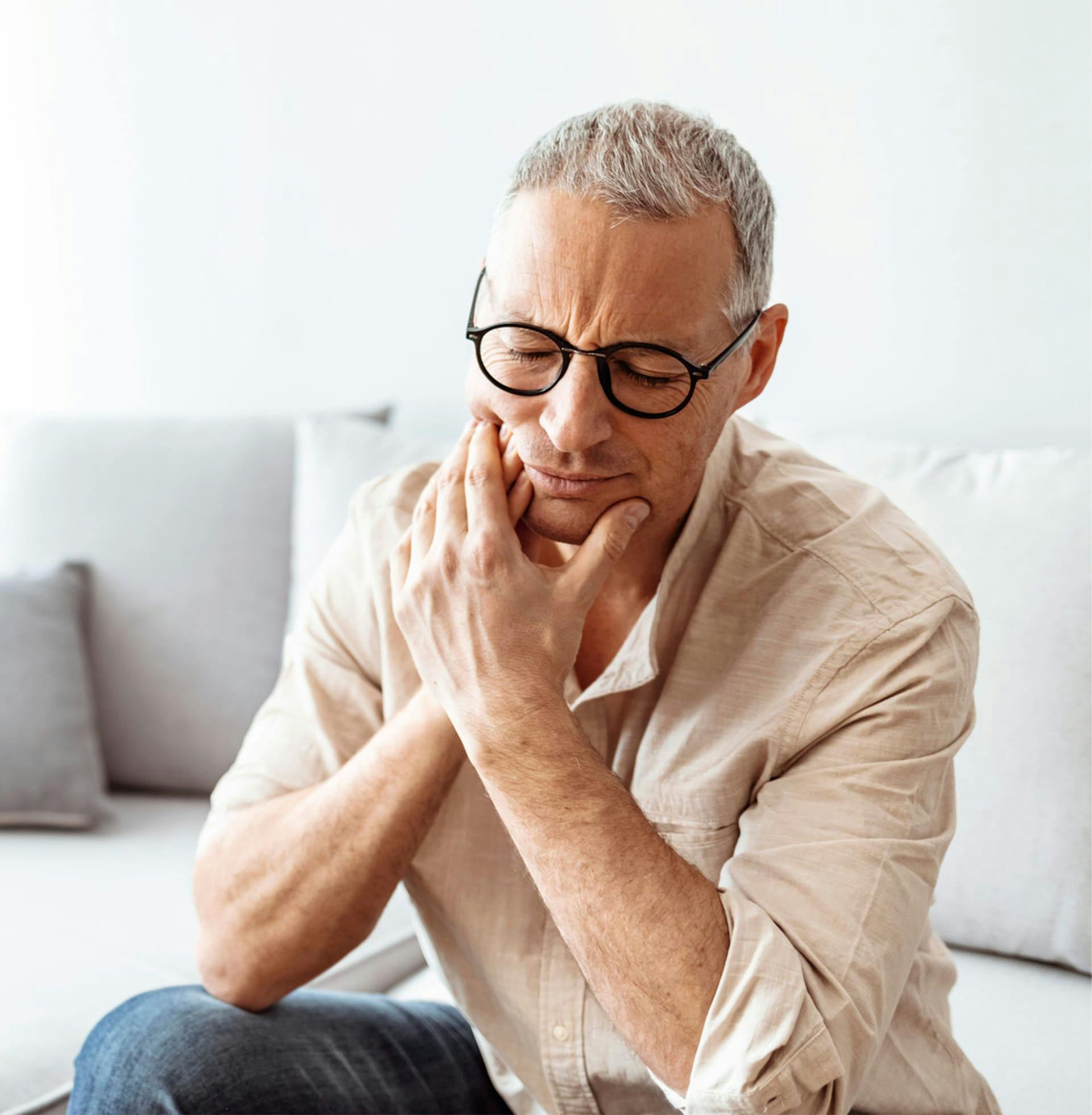 man holding the side of his jaw