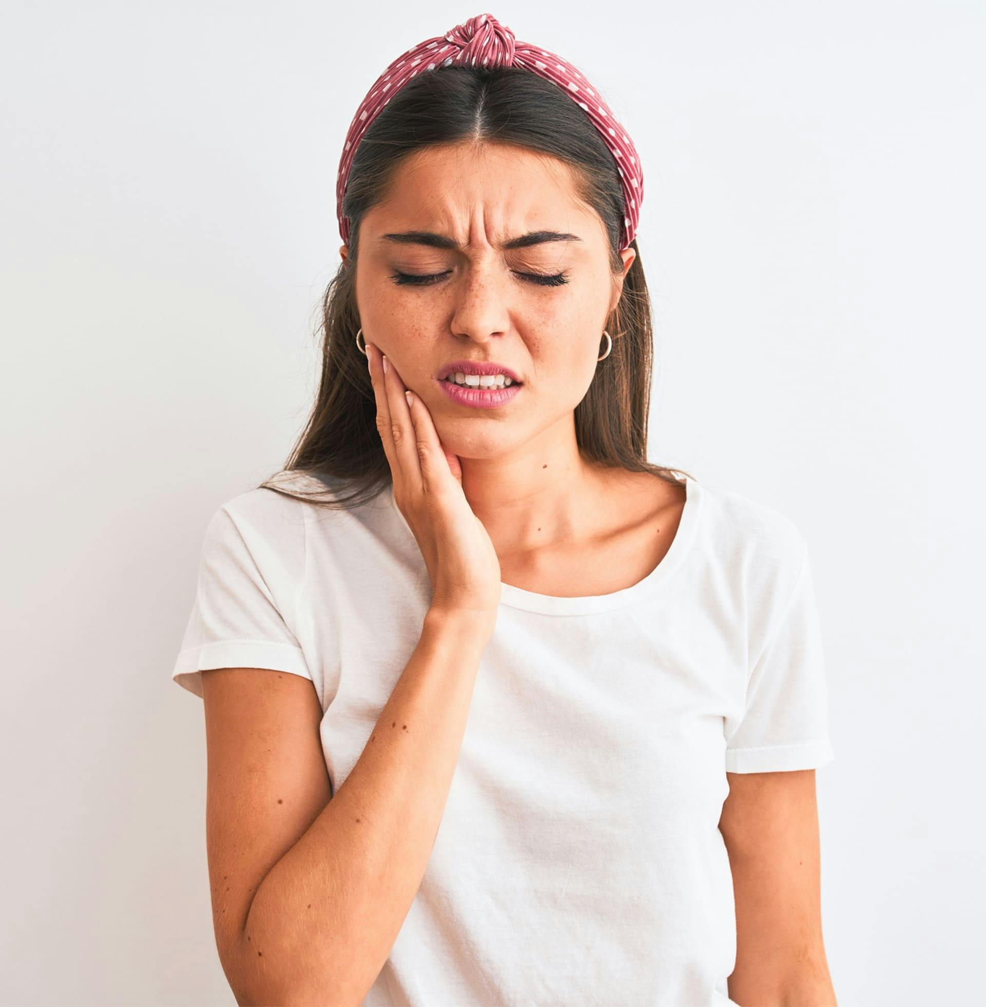 woman touching her cheek in pain