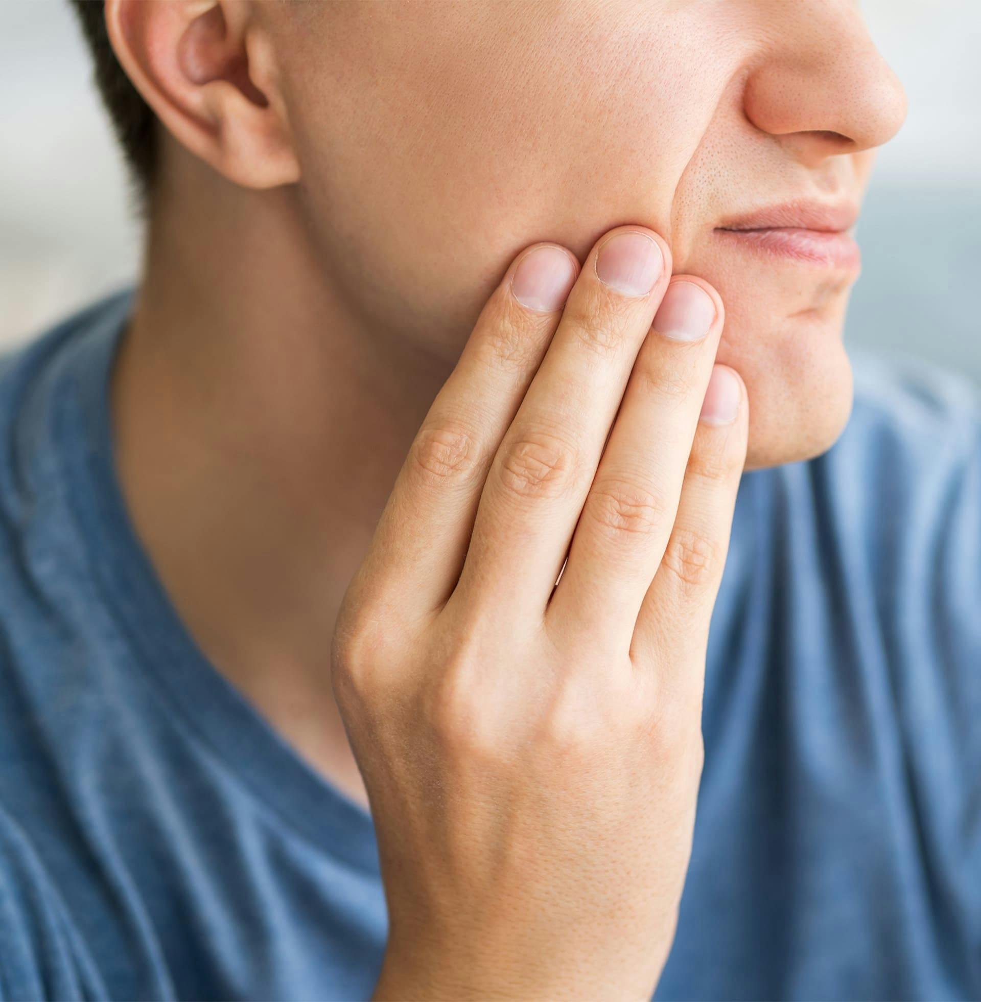 close up on man touching near his mouth showing signs of pain