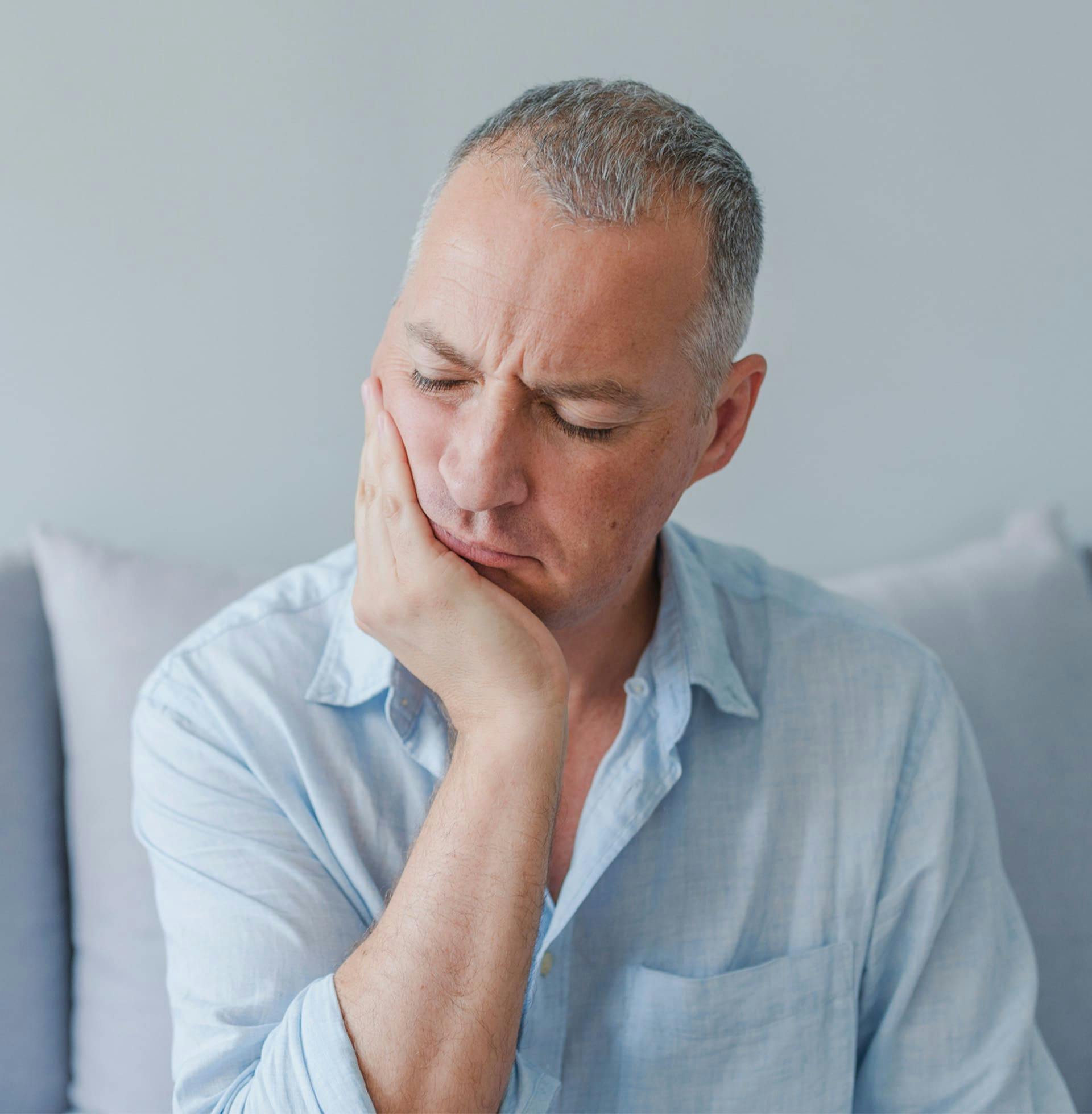 man holding his jaw in pain