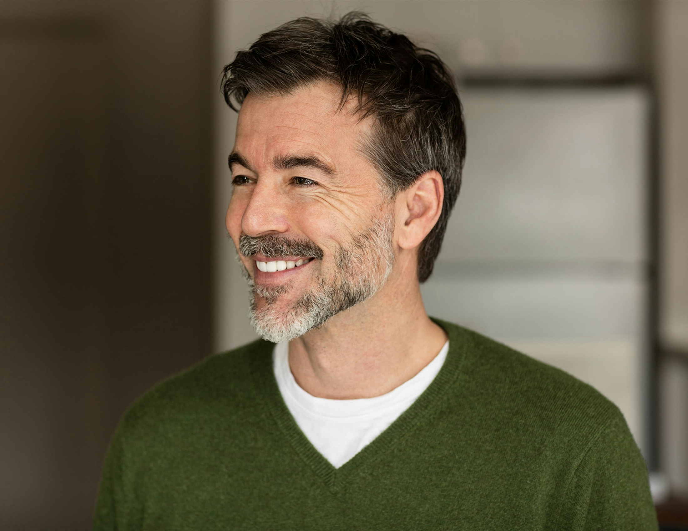 man smiling in green sweater
