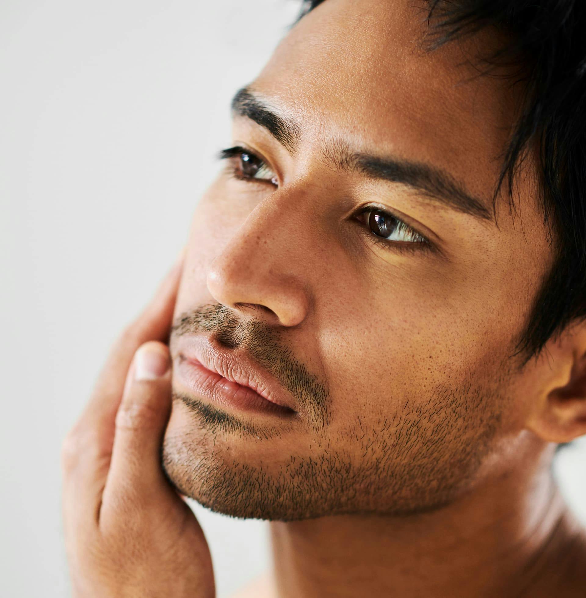 man touching his cheek