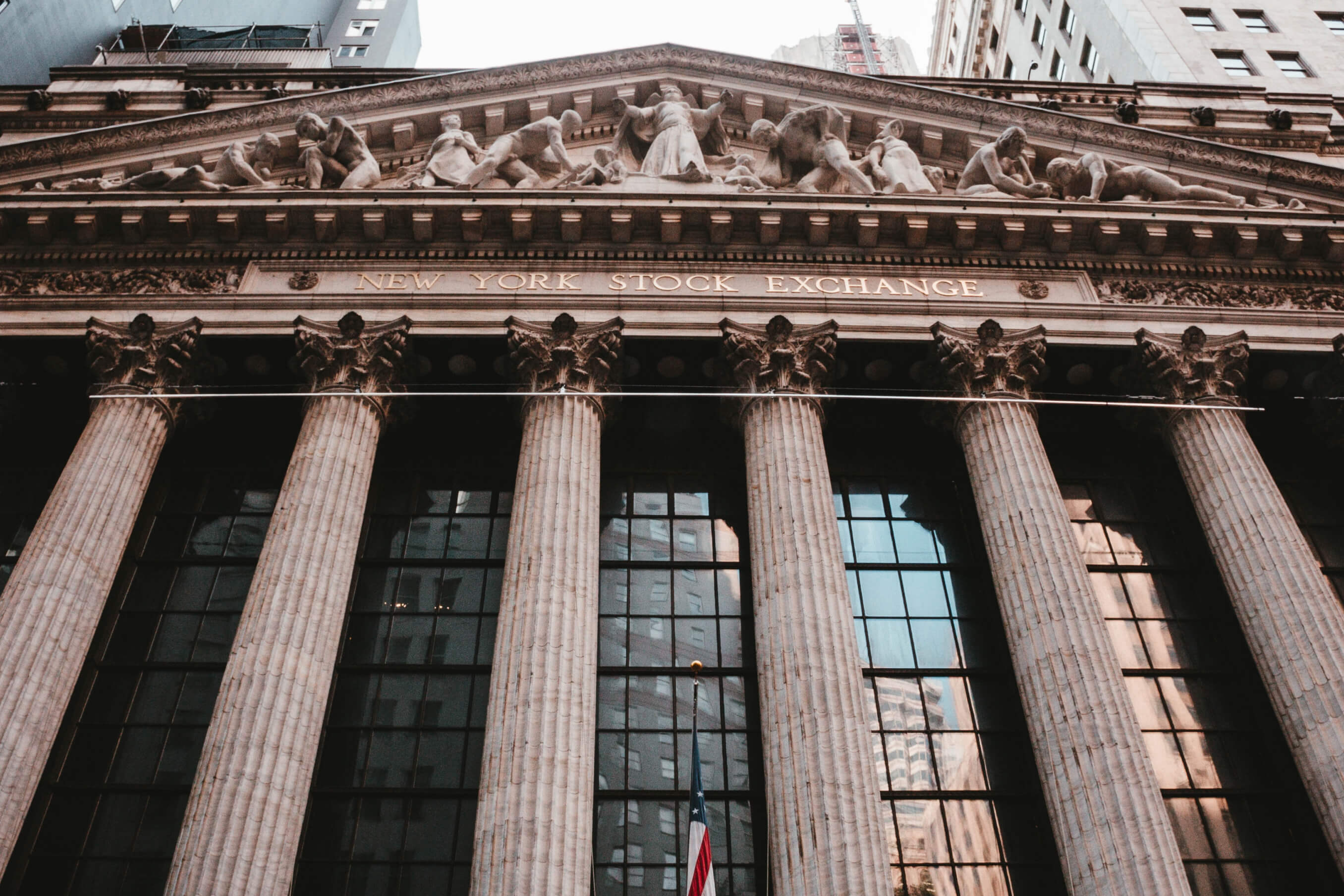 Front view of the New York Stock Exchange building with tall columns and architectural sculptures in Manhattan