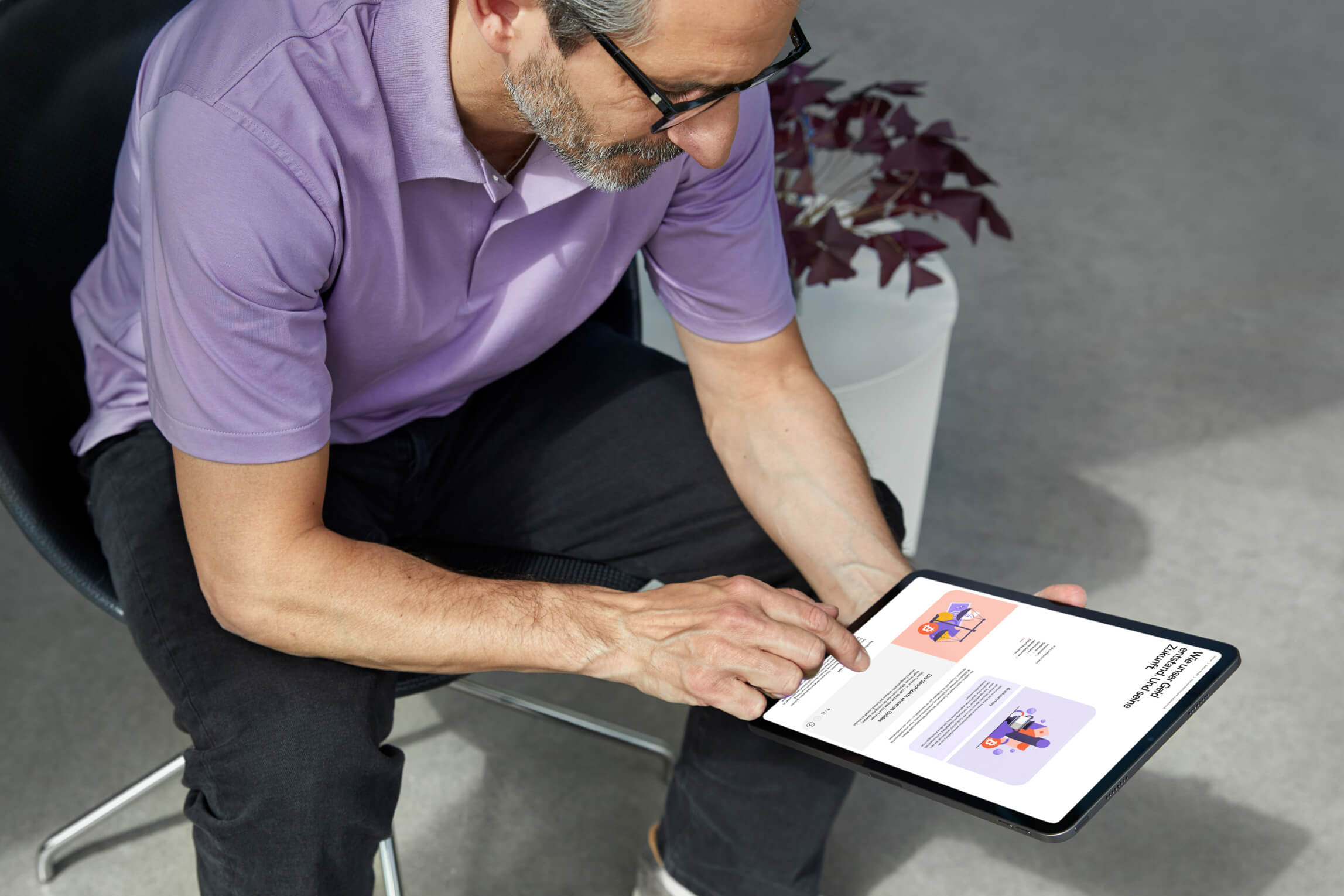 Man in purple shirt sitting and using the Cryptonow app on a tablet to manage cryptocurrencies