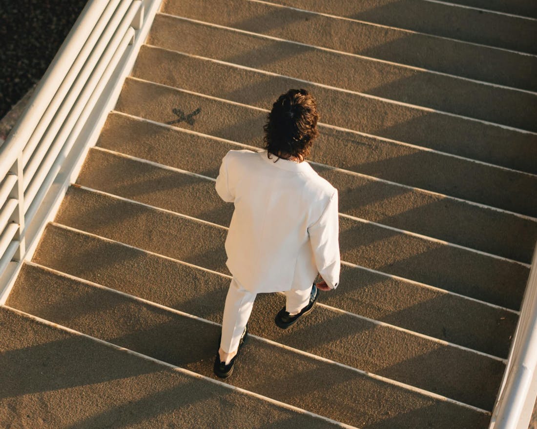 Person in white suit on staircase