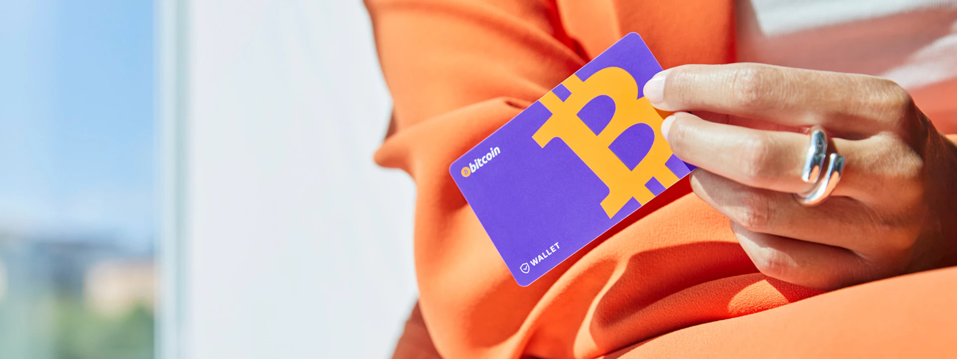 A hand holding the Cryptonow wallet—the easiest and safest way to buy crypto