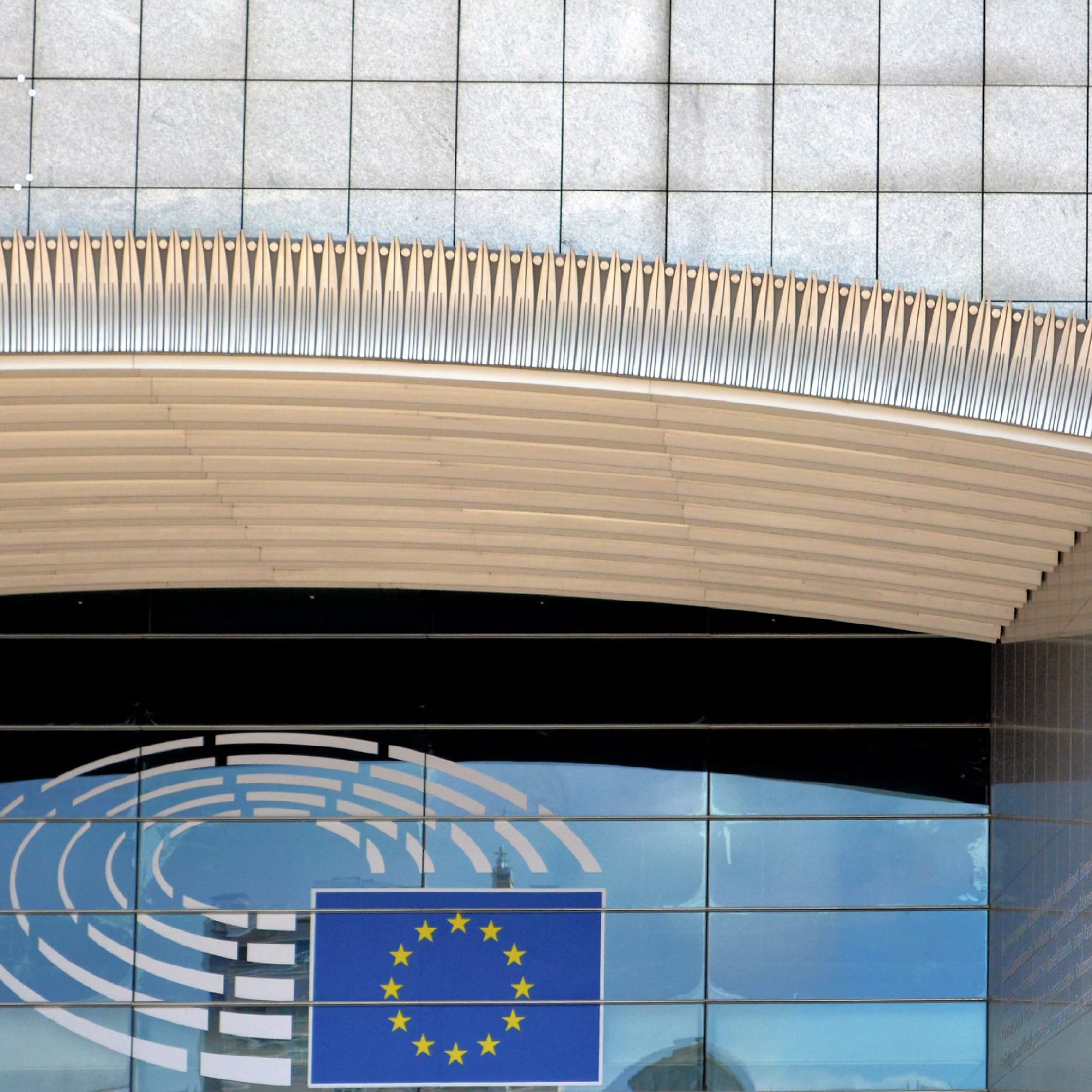 Facade of the European Parliament with EU flag and modern architecture in Brussels