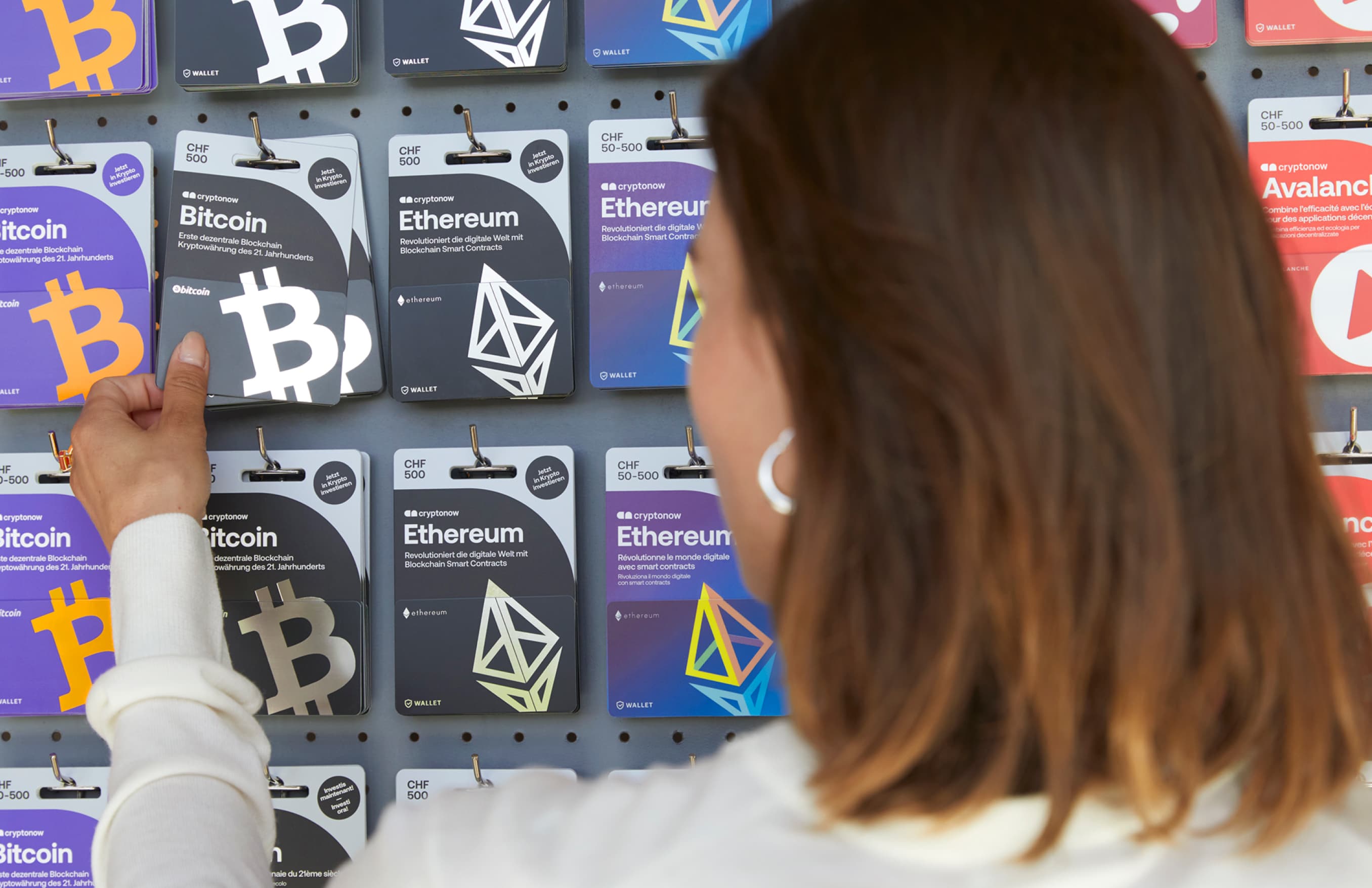 Eine Person kauft im Laden eine Cryptonow Gutscheinkarte