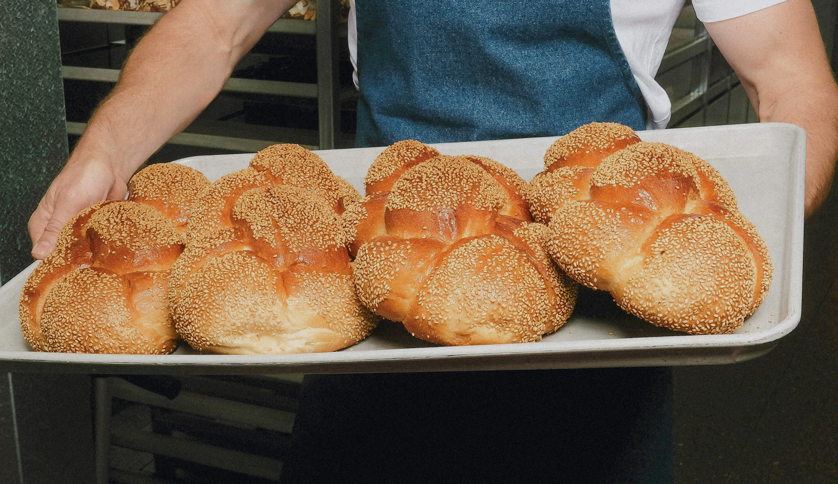Freshly baked challah loaves on a tray at Baker Bleu, handcrafted daily and available for catering, events and special occasions.