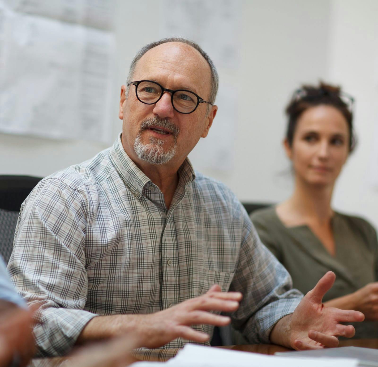 older man talking to a group of people