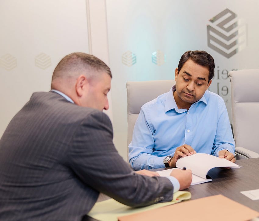 two people signing documents