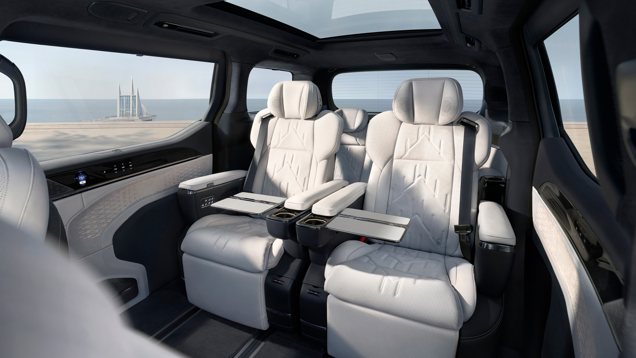 Rear cabin view of the Zeekr 009 luxury electric MPV showcasing the Stone Grey & Polar White interior with Sofaro First-Class seats, foldable tray tables, and a panoramic glass roof.