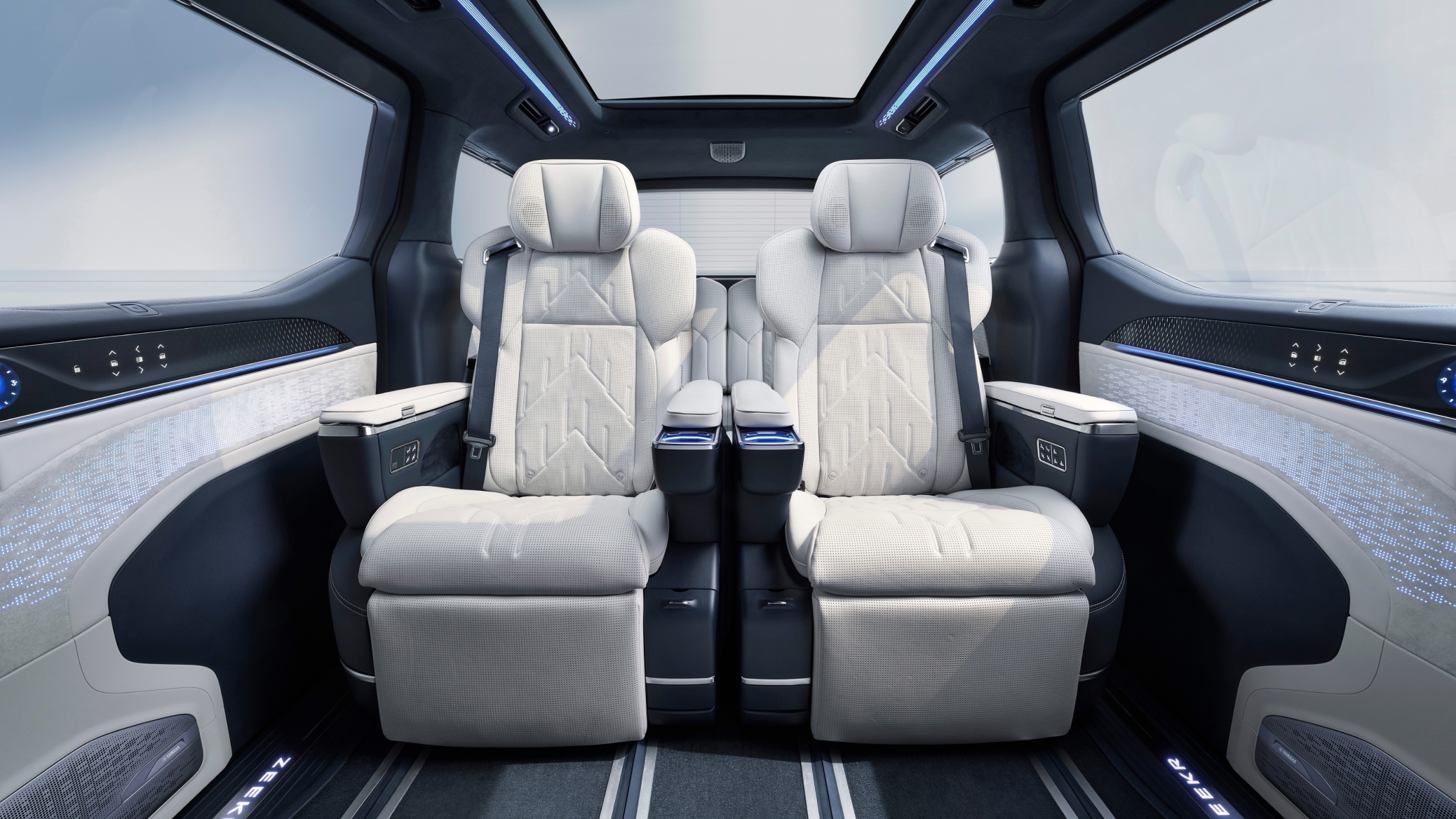 Rear cabin view of the Zeekr 009 luxury electric MPV featuring Sofaro First-Class seats with Nappa leather, reclining leg rests, ambient lighting, and integrated controls for ultimate comfort and sophistication.
