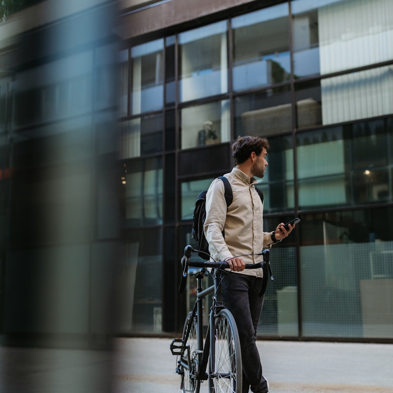 Kille som går med cykel i staden