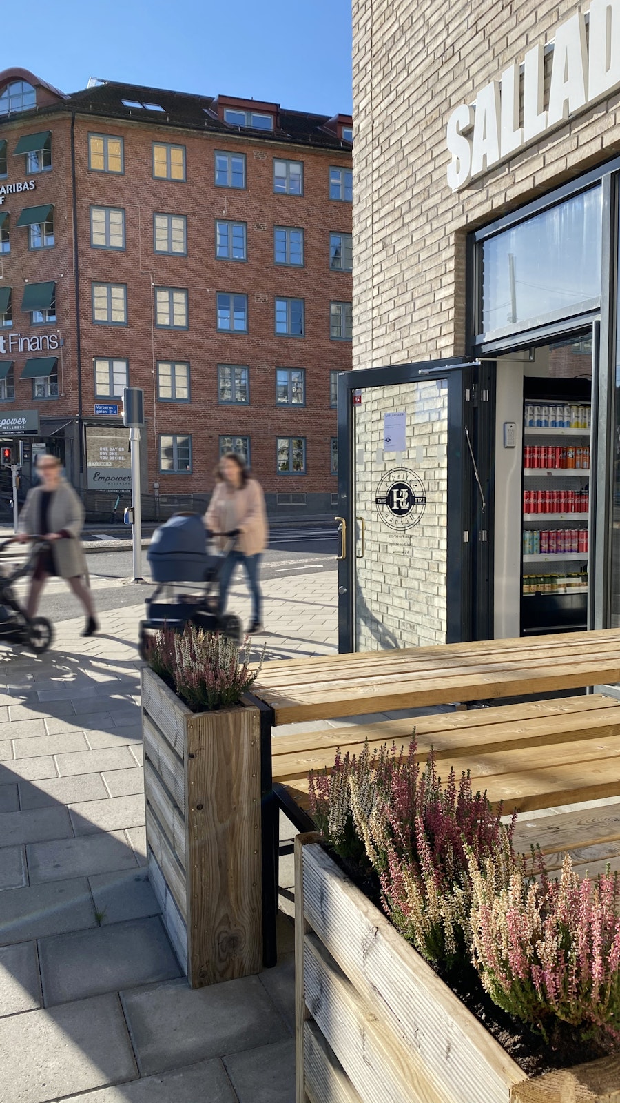 Krokslätt Personer med barnvagnar passerar framför vår fastighet i Krokslätt på Mölndalsvägen med café i förgrunden