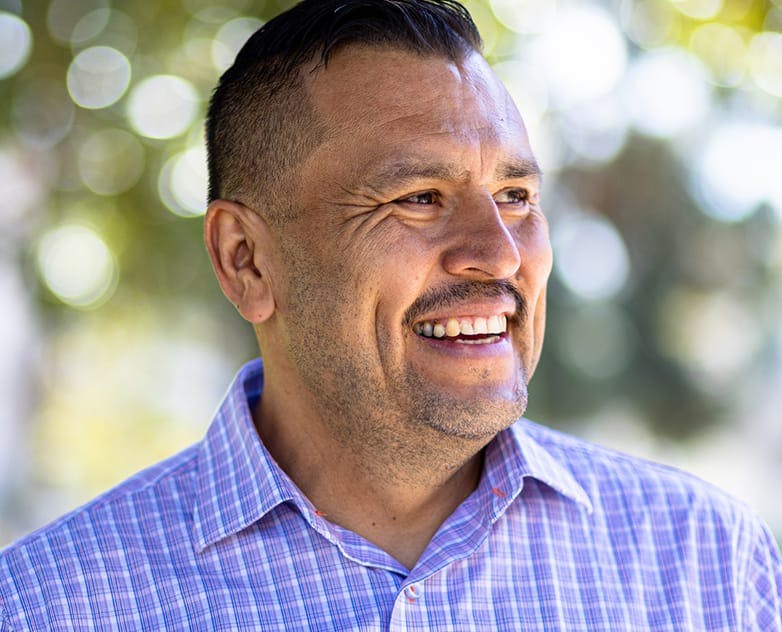 man smiling outside in polo shirt