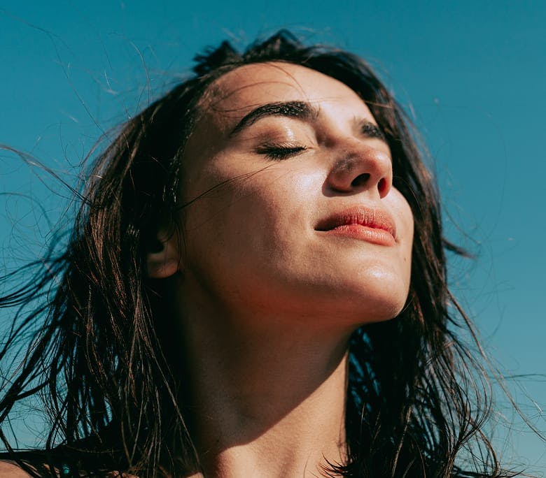woman tilting her head upwards with her eyes closed