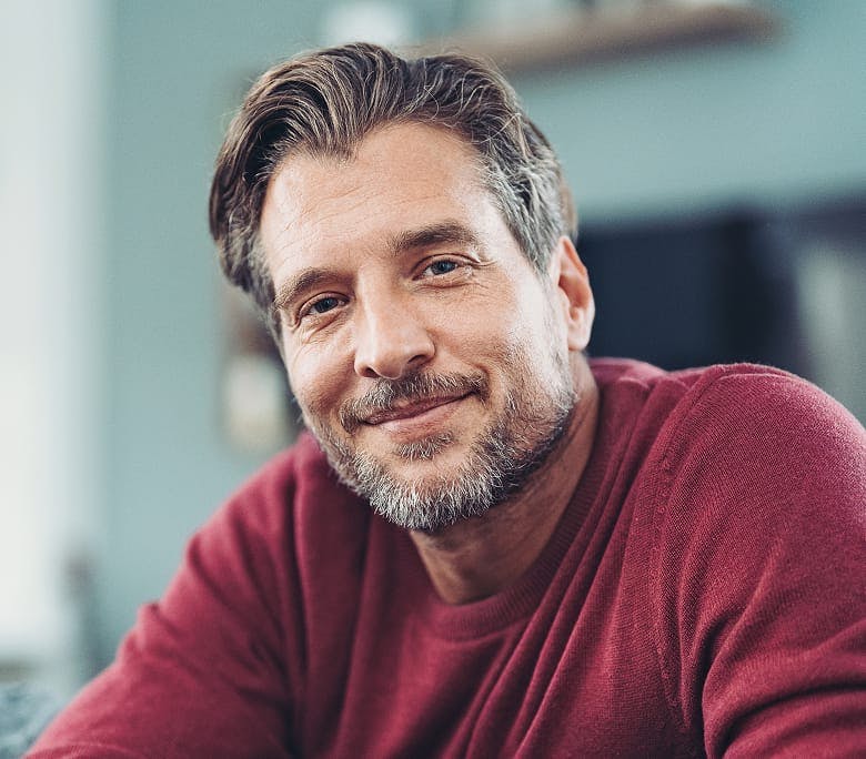 older man in red long sleeve smiling