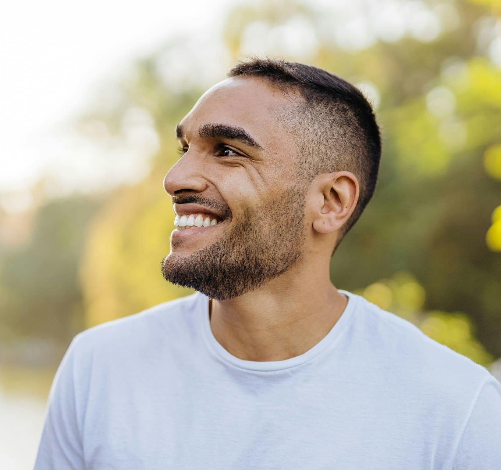 man outside smiling in white t-shirt