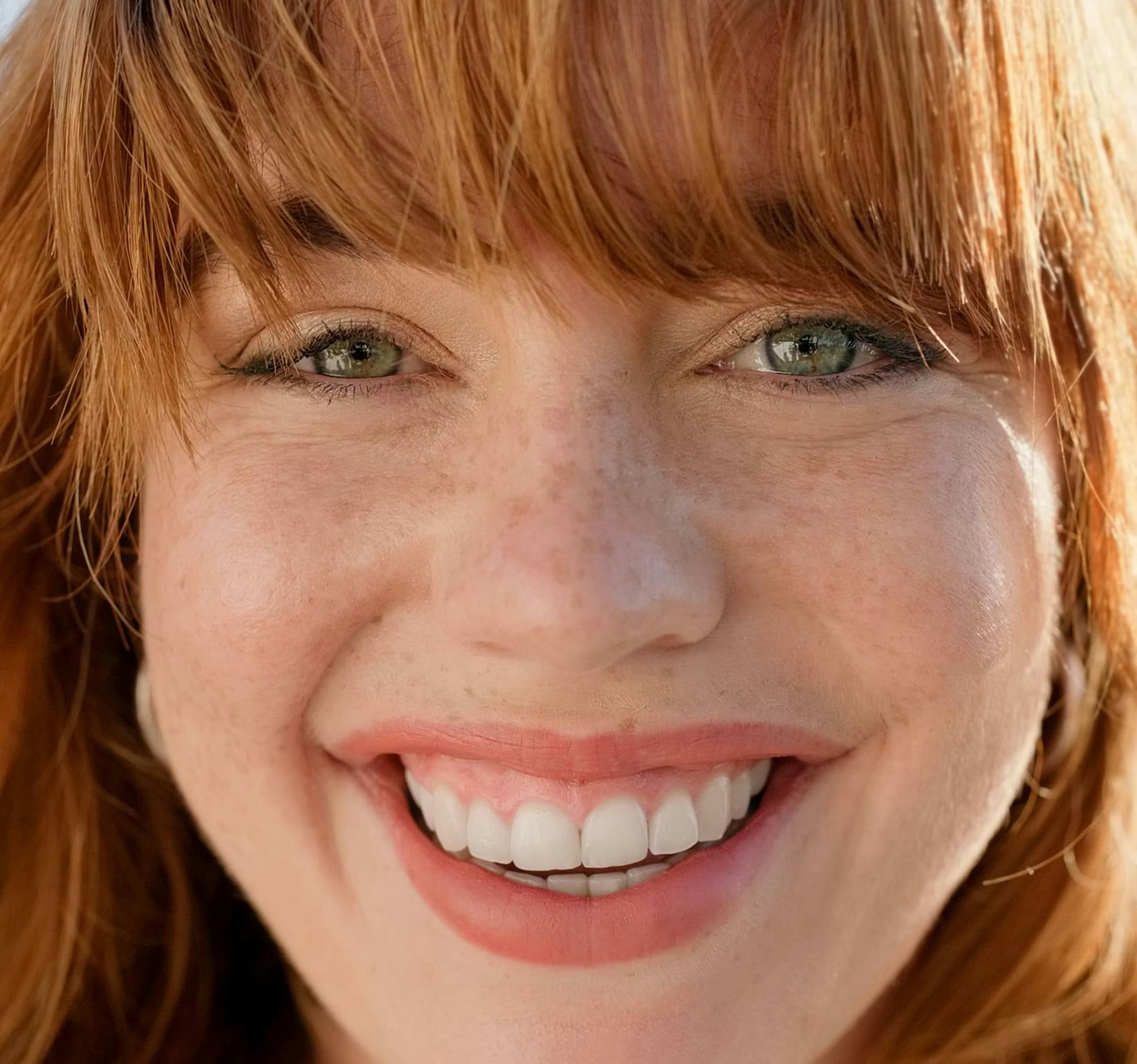 close up on red head woman smiling forward