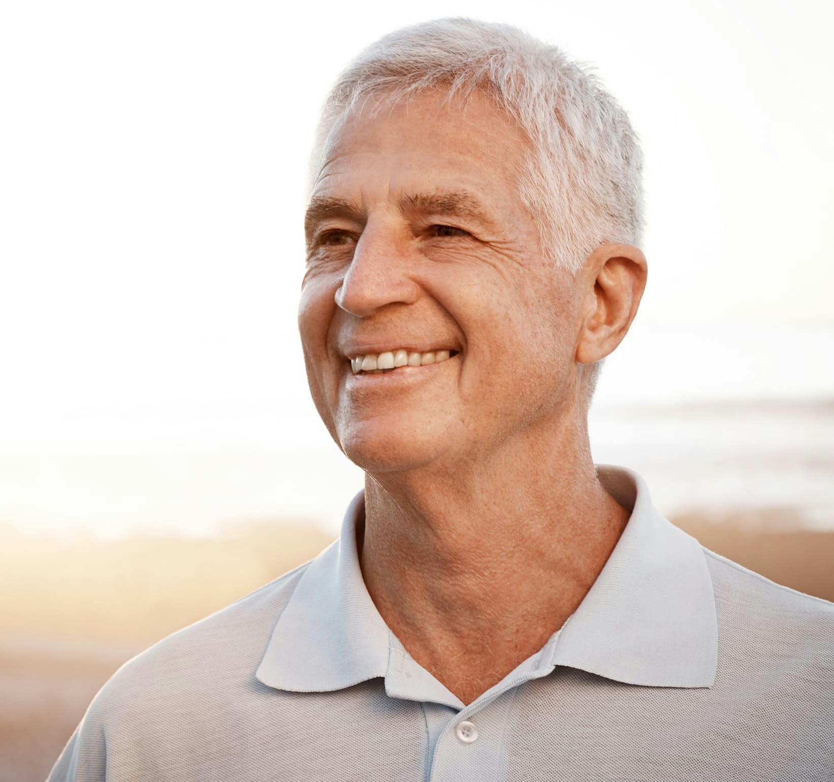 older man on the beach smiling