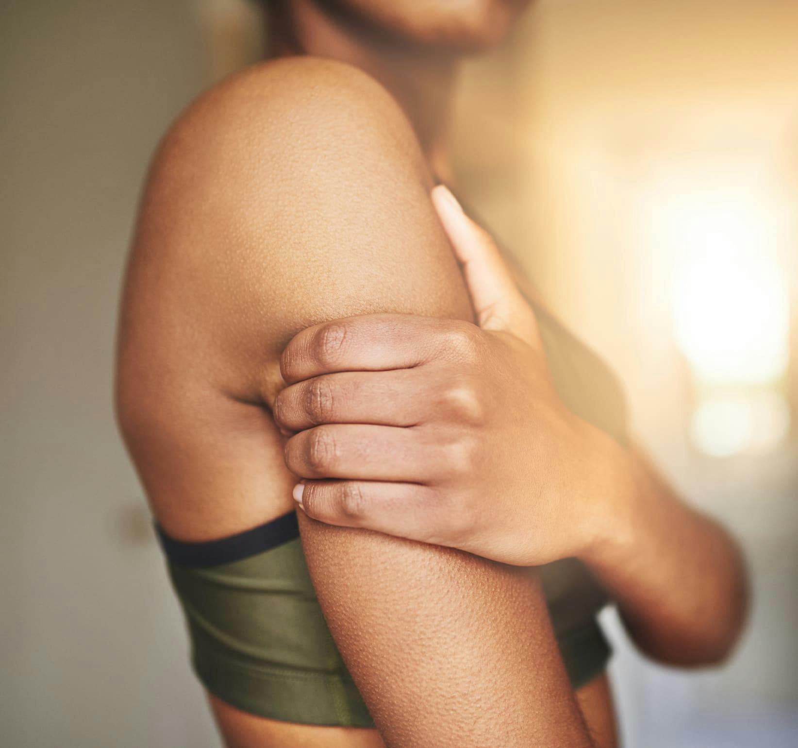 woman grabbing her bicep